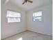 Bright bedroom with two windows and a ceiling fan for added comfort and natural light at 5600 Bay Ne St, St Petersburg, FL 33703