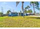 Single-story home with blue exterior, manicured lawn, driveway, and lush trees at 5600 Bay Ne St, St Petersburg, FL 33703