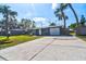 Charming single-story home with blue exterior, driveway, and lush palm trees at 5600 Bay Ne St, St Petersburg, FL 33703
