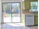 The kitchen has a white dishwasher with green cabinets and access to the patio at 5600 Bay Ne St, St Petersburg, FL 33703