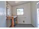 A utility room with water heater, window, workspace, and painted floor at 5600 Bay Ne St, St Petersburg, FL 33703