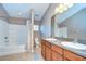 Bathroom featuring dual sinks, a large mirror, tub-shower combo, and tile flooring at 5704 Kingletsound Pl, Lithia, FL 33547
