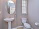 Cozy powder room featuring a pedestal sink, neutral paint, and a framed window with natural light at 5704 Kingletsound Pl, Lithia, FL 33547