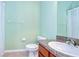Bathroom features a toilet, vanity with sink, mirror, and shower with green walls at 5704 Kingletsound Pl, Lithia, FL 33547