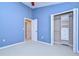 Bright bedroom features blue walls, white trim, and an organized closet with shelves and drawers at 5704 Kingletsound Pl, Lithia, FL 33547