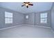 Spacious bedroom with neutral carpet, ceiling fan, and multiple windows for abundant natural light at 5704 Kingletsound Pl, Lithia, FL 33547