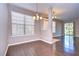 Bright dining room with hardwood floors, large windows, and stylish light fixtures at 5704 Kingletsound Pl, Lithia, FL 33547