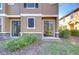 Exterior of townhouse featuring stone accents, sliding glass doors, and well-maintained landscaping at 5704 Kingletsound Pl, Lithia, FL 33547