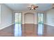Expansive living room featuring hardwood floors, natural light, and slider doors to the backyard at 5704 Kingletsound Pl, Lithia, FL 33547