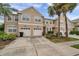 Inviting two-story townhome with two car garage, driveway, and tropical landscaping at 585 Black Lion Ne Dr, St Petersburg, FL 33716