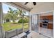 Cozy lanai seating area with screened enclosure and kitchen view of stainless steel appliances at 585 Black Lion Ne Dr, St Petersburg, FL 33716