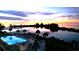 Aerial view featuring a pool overlooking the water with a colorful sunset at 6009 Sea Ranch Dr # 307, Hudson, FL 34667