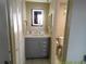 Modern bathroom featuring a gray vanity, an illuminated mirror, and neutral finishes in a well-lit space at 6009 Sea Ranch Dr # 307, Hudson, FL 34667