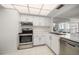 Modern white kitchen with stainless steel oven, white cabinets and tiled floor at 6279 Sun Blvd # 605, St Petersburg, FL 33715