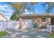 Side view of the home showing the garage, well-maintained yard, and clean white privacy fence at 6315 25Th N Ave, St Petersburg, FL 33710