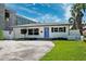 Classic home exterior featuring a well-maintained lawn, tidy landscaping, and a vibrant blue front door at 735 Snell Isle Ne Blvd, St Petersburg, FL 33704