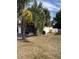 Spacious backyard surrounded by mature palm trees, with a metal bench, and a white fence at 8630 Winter Haven Dr, Hudson, FL 34667