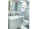 This bathroom features white marble tiling, a white toilet, and a gray vanity at 8630 Winter Haven Dr, Hudson, FL 34667