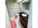 This bathroom features white marble tiling, a white toilet, and a dark vanity at 8630 Winter Haven Dr, Hudson, FL 34667