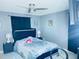 Comfortable bedroom featuring a ceiling fan, large black headboard and light blue walls at 8630 Winter Haven Dr, Hudson, FL 34667