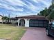 Charming single-story home featuring a stone accent wall, arched entry, and a spacious two-car garage at 8630 Winter Haven Dr, Hudson, FL 34667