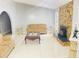 Bright living room featuring a stone fireplace, modern tile floors, and comfortable furnishings at 8630 Winter Haven Dr, Hudson, FL 34667