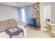 Cozy living room featuring a stone fireplace, natural light, and stylish decor at 8630 Winter Haven Dr, Hudson, FL 34667
