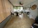 The sunroom with tiled floors, ceiling fan, large windows, and glass topped outdoor furniture at 8630 Winter Haven Dr, Hudson, FL 34667
