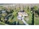 An aerial view showcases a house with mature landscaping, a long driveway, and ample parking space at 8946 Old Pasco Rd, Wesley Chapel, FL 33544