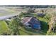 Aerial view of a property featuring a screened-in pool, pond, lush landscaping, barn and long driveway at 8946 Old Pasco Rd, Wesley Chapel, FL 33544