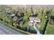 Aerial view of a property featuring mature landscaping, a barn, a home with a pond, and a long driveway at 8946 Old Pasco Rd, Wesley Chapel, FL 33544