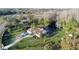Aerial view featuring lush greenery surrounding a beautiful home with screened in pool and long drive at 8946 Old Pasco Rd, Wesley Chapel, FL 33544
