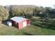 A red barn with a white door, with the house visible in the background at 8946 Old Pasco Rd, Wesley Chapel, FL 33544