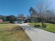 Expansive home exterior featuring a circular driveway, mature landscaping, and a well-manicured lawn at 8946 Old Pasco Rd, Wesley Chapel, FL 33544