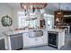 Bright kitchen with stainless steel appliances, farmhouse sink, granite counters, and suspended pot rack at 8946 Old Pasco Rd, Wesley Chapel, FL 33544