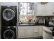 Well-lit laundry room featuring modern appliances, counter space, and a view to the outside at 8946 Old Pasco Rd, Wesley Chapel, FL 33544