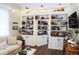 Living room featuring built-in shelving with a hidden door, hardwood floors, sofa, and decorative accents at 8946 Old Pasco Rd, Wesley Chapel, FL 33544