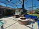 Beautiful outdoor patio area with a stone fire pit, bar, grill and comfortable seating at 8946 Old Pasco Rd, Wesley Chapel, FL 33544