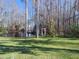 A sunny yard featuring a pond with trees and an arbor in the background at 8946 Old Pasco Rd, Wesley Chapel, FL 33544