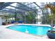 Inviting pool with a seating area and outdoor kitchen, perfect for entertaining under a screened enclosure at 8946 Old Pasco Rd, Wesley Chapel, FL 33544