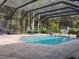 Enclosed pool with lounge chairs, lush greenery, and ample space for recreation at 8946 Old Pasco Rd, Wesley Chapel, FL 33544