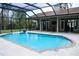 Spacious screened-in pool with stone decking and covered patio, perfect for lounging or Gathering fun at 8946 Old Pasco Rd, Wesley Chapel, FL 33544