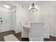 Cozy dining room featuring dark wood floors, white walls and furniture, and a round chandelier at 17106 Carrington Park Dr # 627, Tampa, FL 33647