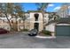 Exterior view of condo building with palm trees, parking and garages with a bright blue sky at 17106 Carrington Park Dr # 627, Tampa, FL 33647