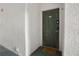 Close-up of a unit's dark green front door, with a textured wall and welcome mat at 17106 Carrington Park Dr # 627, Tampa, FL 33647