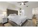Bedroom with a large upholstered bed, ceiling fan, and neutral decor at 17106 Carrington Park Dr # 627, Tampa, FL 33647
