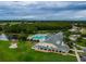 Aerial view of clubhouse, pool, golf course, and surrounding trees at 10416 Moshie Ln, San Antonio, FL 33576