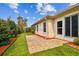 Backyard with manicured garden and patio extending from the home's exterior with lush and established greenery at 10416 Moshie Ln, San Antonio, FL 33576