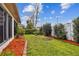 Well-maintained backyard featuring lush green grass, a planting space, and manicured shrubs and landscape at 10416 Moshie Ln, San Antonio, FL 33576