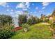 Green backyard showcasing a garden with privacy landscaping and a tiled area, ideal for relaxing outdoors at 10416 Moshie Ln, San Antonio, FL 33576